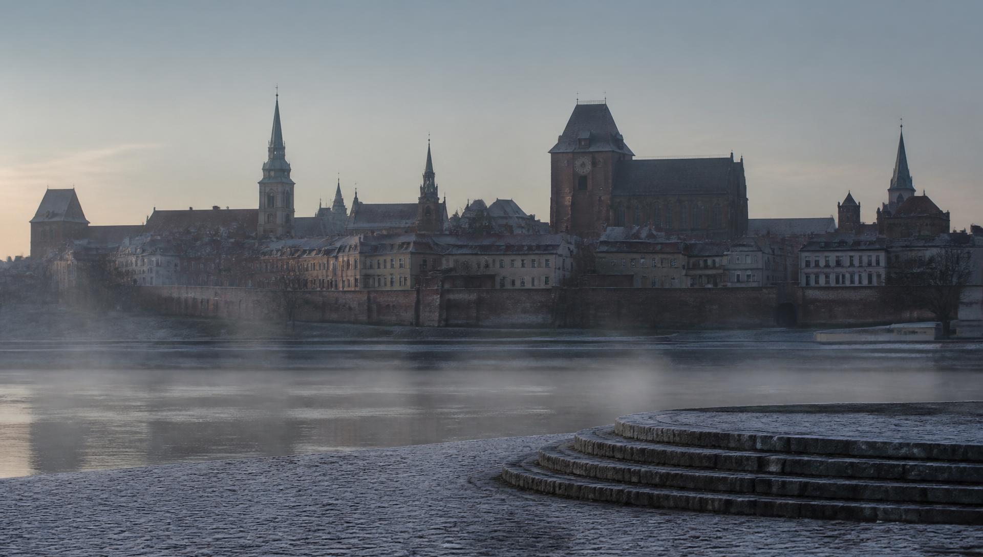 Toruń Old Town at first light, seen across the Vistula in early November.